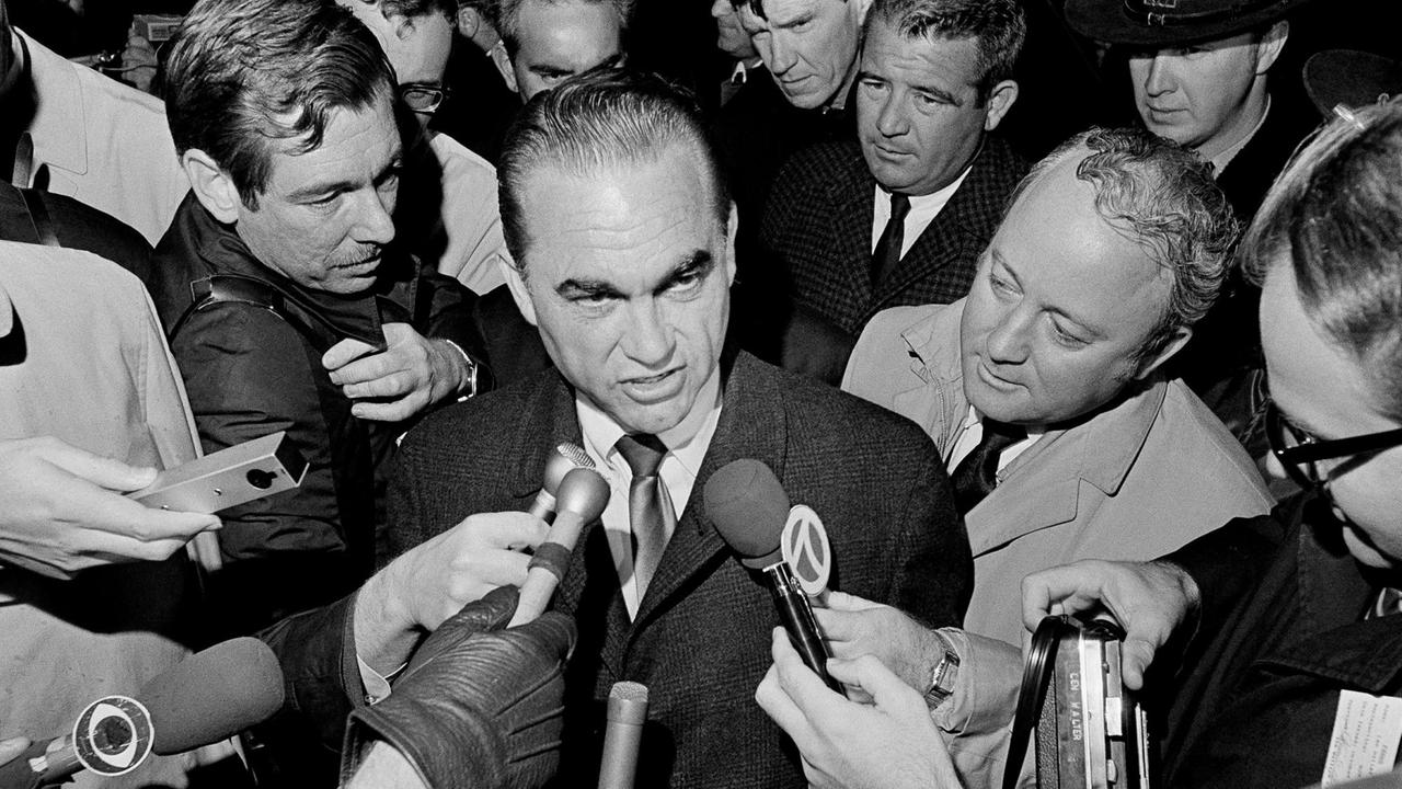 Historische Aufnahme von 1968. George Wallace, Präsidentschaftskandidat und ehemaliger Gouverneur von Alabama, wird am Metro Airport in Detroit von Reportern umringt. Historische Aufnahme von 1968. George Wallace, Präsidentschaftskandidat und ehemaliger Gouverneur von Alabama, wird am Metro Airport in Detroit von Reportern umringt.
