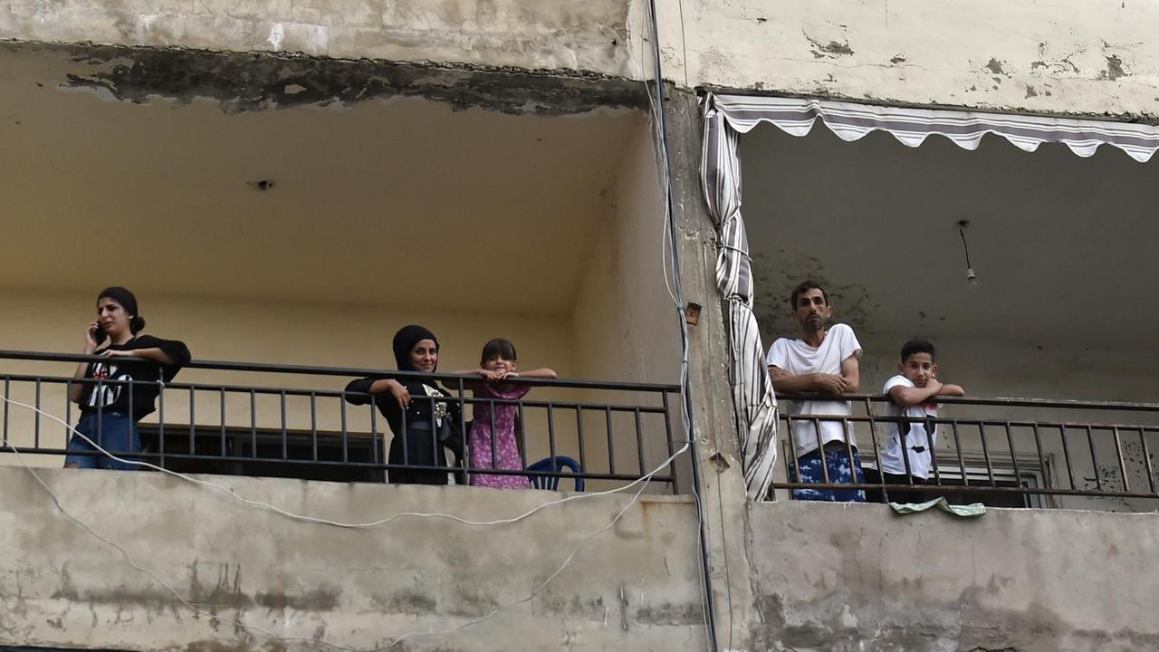 Menschen auf Balkonen eines Wohnhauses in Beirut, im Libanon, warten einen Stromausfall ab.