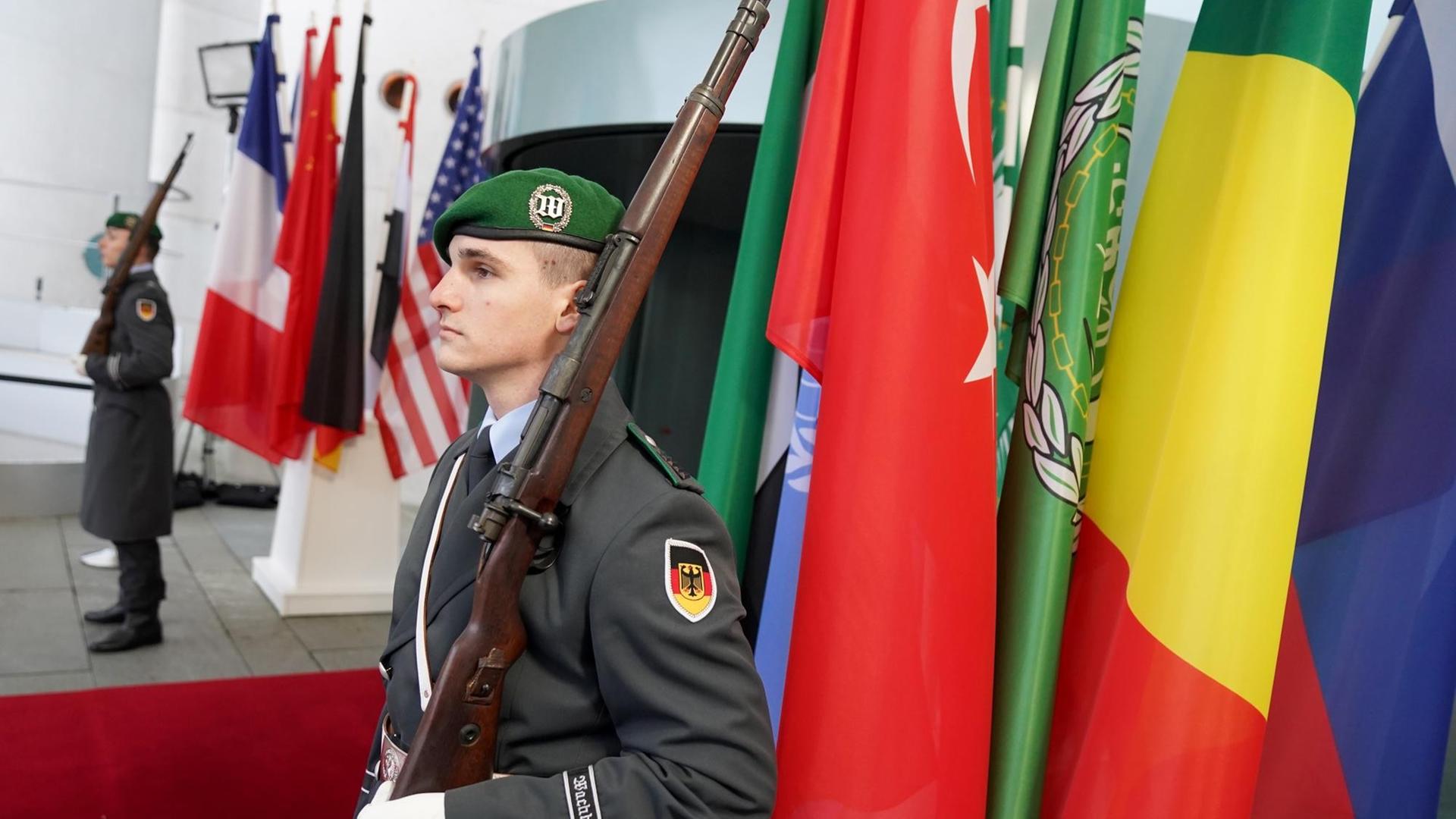 Wachposten der Bundeswehr stehen vor den Flaggen der Teilnehmerstaaten der Libyenkonferenz vor dem Bundeskanzleramt Wachposten der Bundeswehr stehen vor den Flaggen der Teilnehmerstaaten der Libyenkonferenz vor dem Bundeskanzleramt
