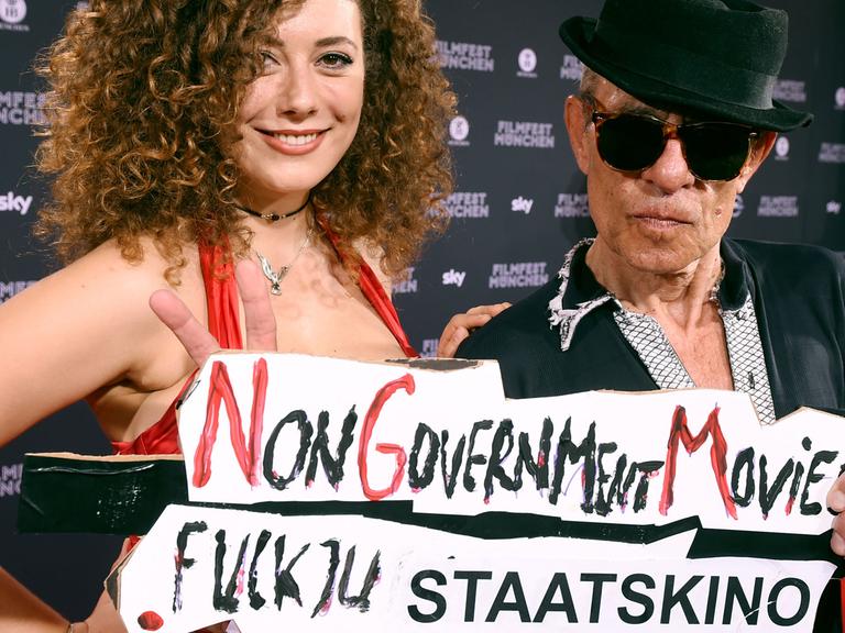 Der Regisseur Klaus Lemke und Begleitung Leila Lowfire stehen bei der Eröffnung des Filmfests München auf dem Roten Teppich