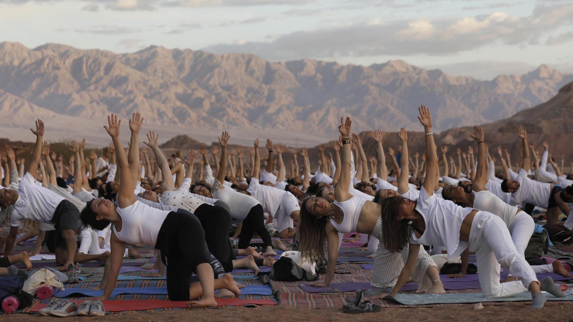 Tausend Yogis üben gemeinsam in der Arava Wüste in Israel Yoga.