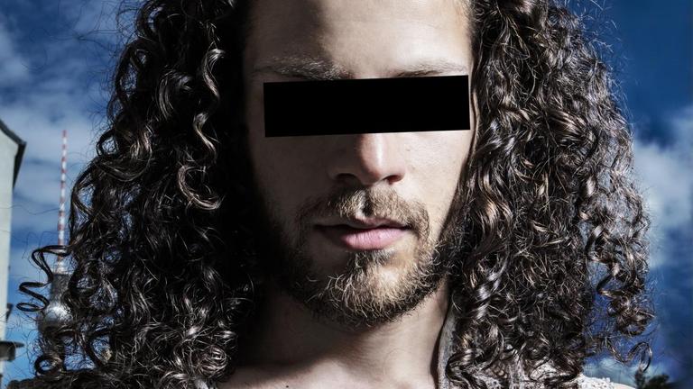 Ein Mann mit langen Haaren hat einen schwarzen Balken vor den Augen, um unkenntlich zu bleiben. Ein Mann mit langen Haaren hat einen schwarzen Balken vor den Augen, um unkenntlich zu bleiben.