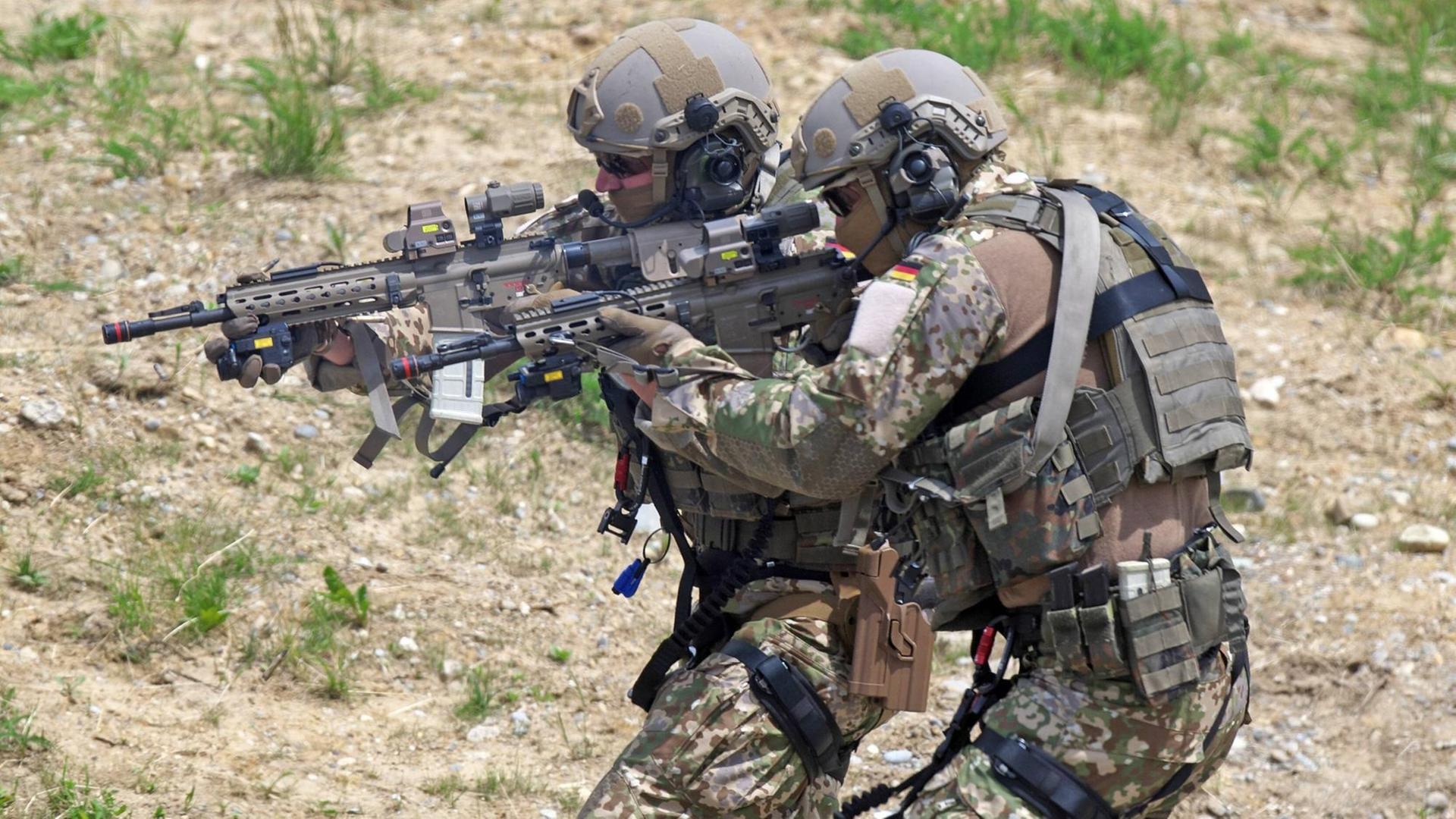 Zwei Soldaten des Kommandos Spezialkräfte in Kampfuniform und mit Waffen Zwei Soldaten des Kommandos Spezialkräfte in Kampfuniform und mit Waffen