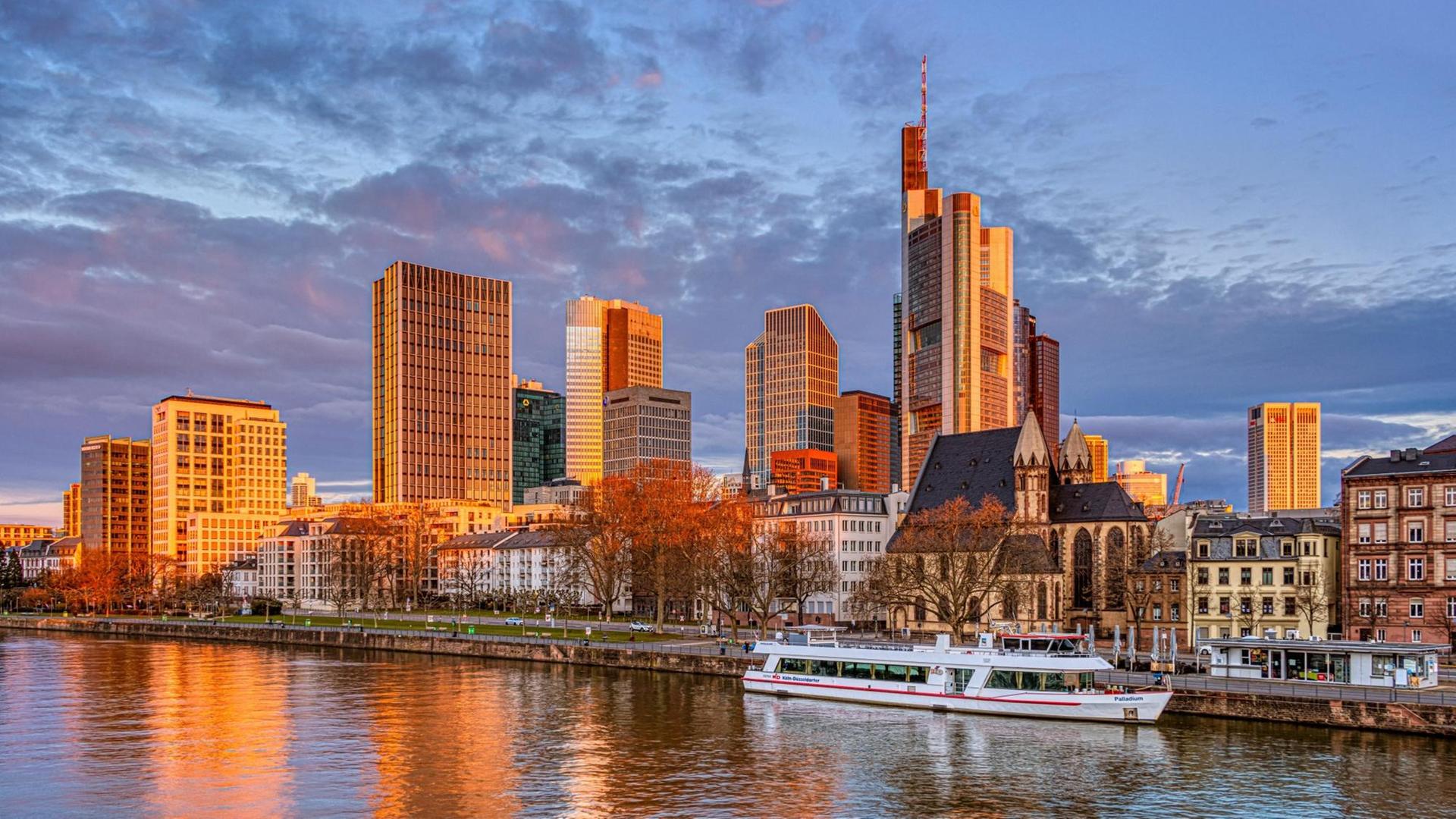 Die Hochhäuser der Frankfurter Skyline leuchten bei Sonnenaufgang orange. Die Hochhäuser der Frankfurter Skyline leuchten bei Sonnenaufgang orange.
