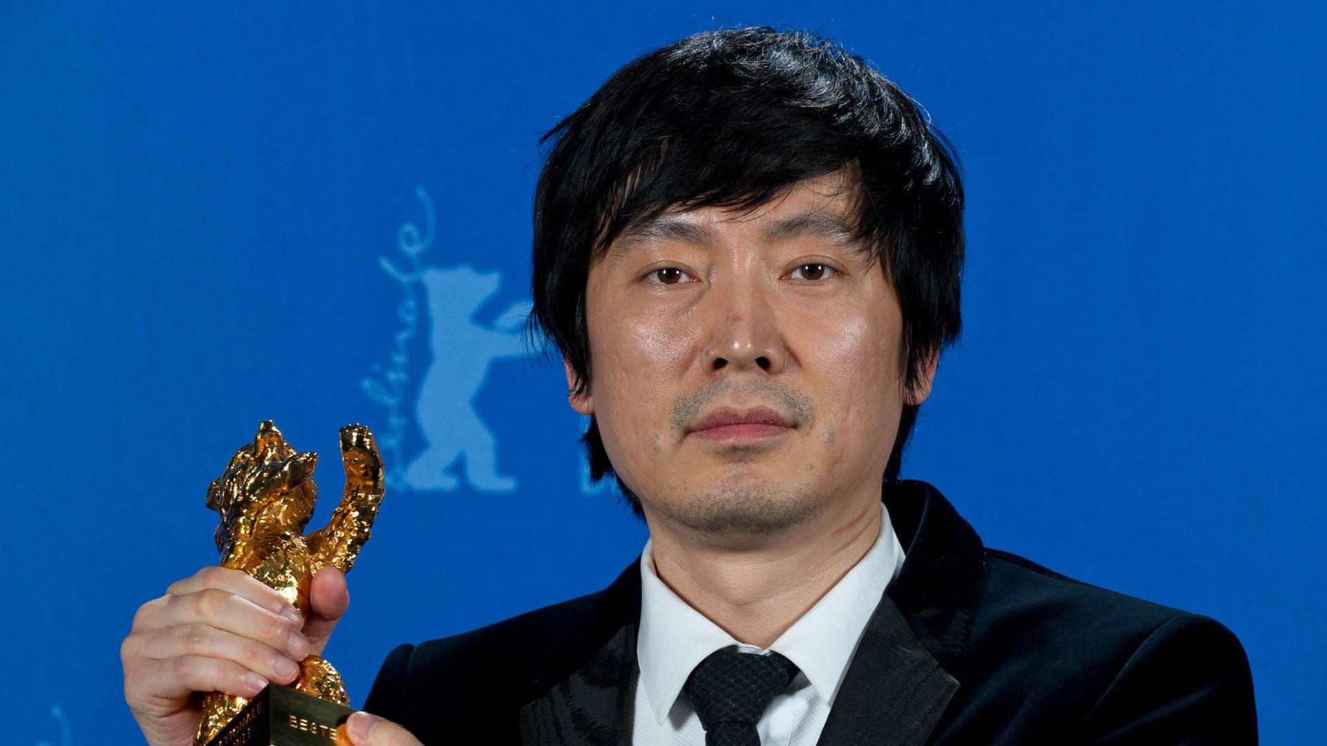 Diao Yinan, der Regisseur des Siegerfilms "Bai Ri Yan Huo (Schwarze Kohle, dünnes Eis)", posiert während der 64. Internationalen Filmfestspiele in Berlin mit dem Goldenen Bären. Diao Yinan, der Regisseur des Siegerfilms "Bai Ri Yan Huo (Schwarze Kohle, dünnes Eis)", posiert während der 64. Internationalen Filmfestspiele in Berlin mit dem Goldenen Bären.