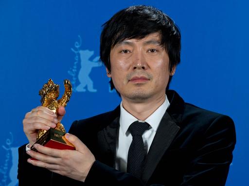Diao Yinan, der Regisseur des Siegerfilms "Bai Ri Yan Huo (Schwarze Kohle, dünnes Eis)", posiert während der 64. Internationalen Filmfestspiele in Berlin mit dem Goldenen Bären.