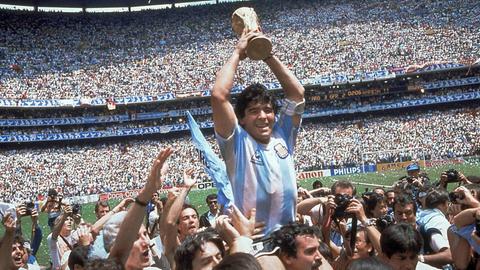 Diego Maradona lässt sich von seinen Mitspielern auf Schultern durchs Stadion tragen und hält den UEFA-Pokal triumphierend in die Luft.
