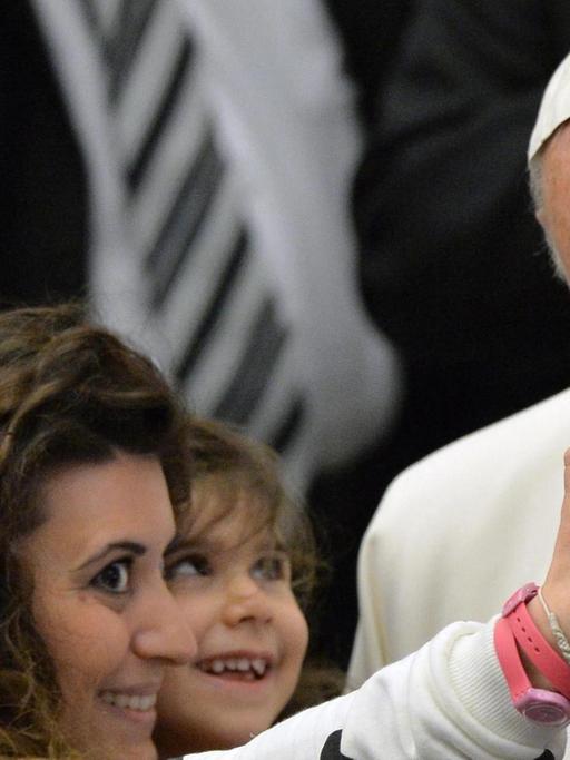 Eine Mutter macht ein Selfie von sich, ihrem Kind und Papst Franziskus während einer Generalaudienz.