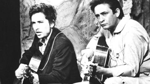 Johnny Cash und Bob Dylan spielen auf ihren Gitarren zusammen.