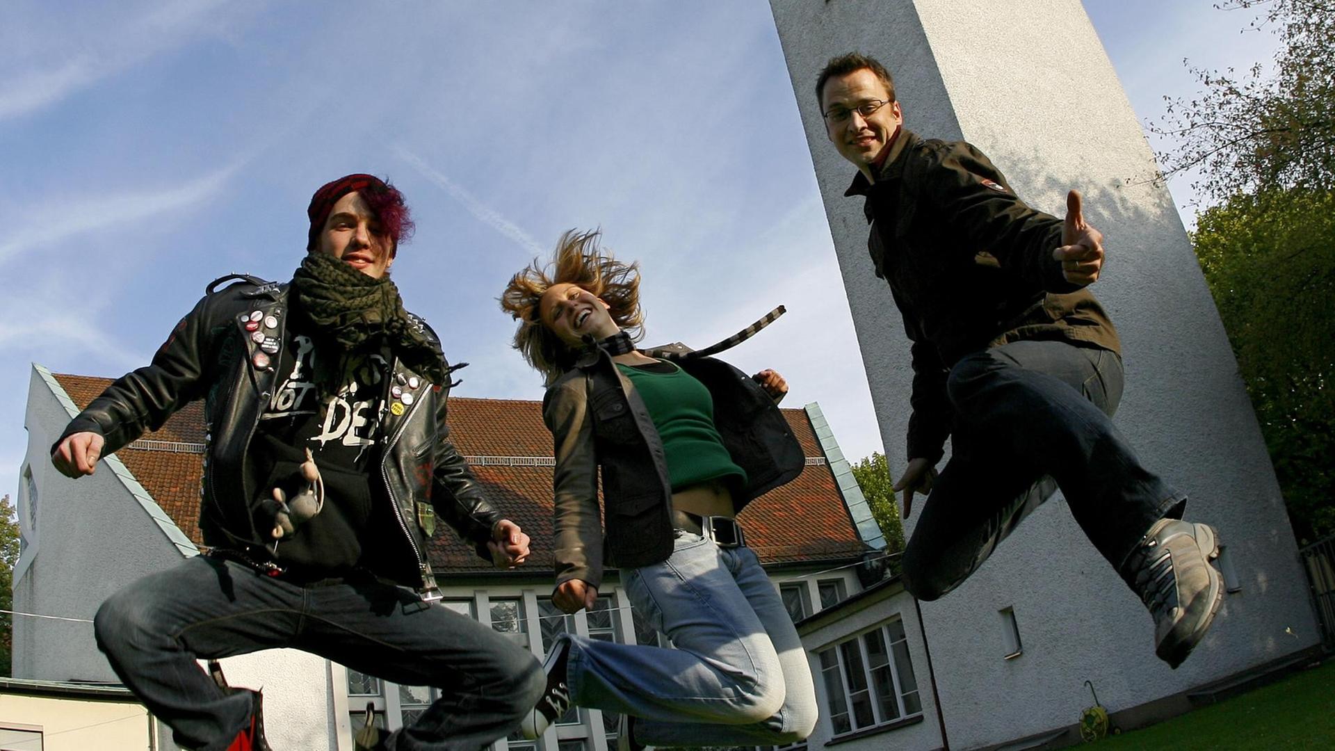 Springend präsentiert sich für den Fotografen die Theologin Daniela Mailänder und zwei ihrer Kollegen der evangelischen Jugendkirche Lux in Nürnberg