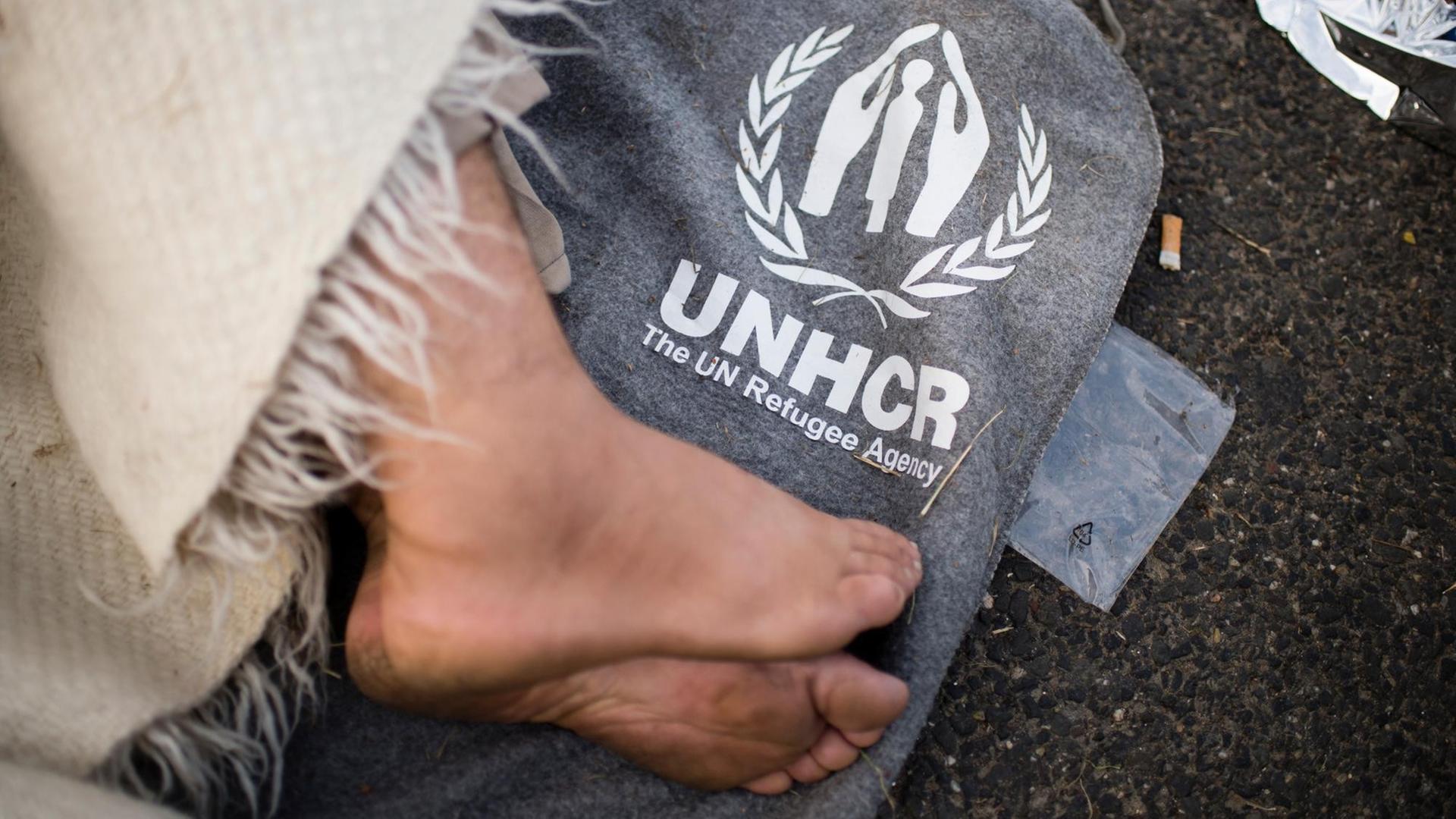 Ein Flüchtling schläft auf einer Decke des Hilfswerk der Vereinten Nationen (UNHCR) auf der Straße zum Grenzübergang nach Ungarn bei Horgos in Serbien.