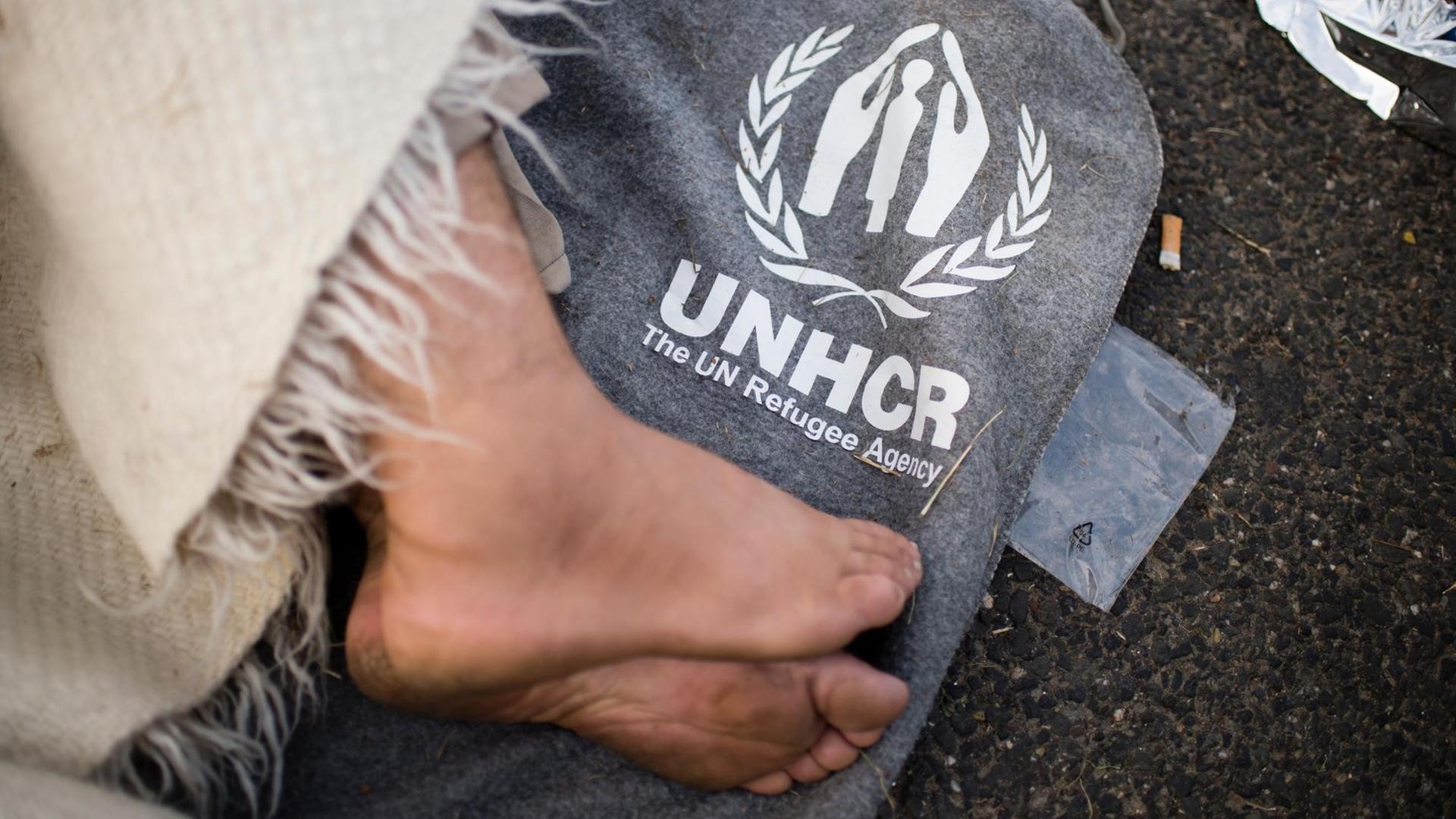 Ein Flüchtling schläft auf einer Decke des Hilfswerk der Vereinten Nationen (UNHCR) auf der Straße zum Grenzübergang nach Ungarn bei Horgos in Serbien. Ein Flüchtling schläft auf einer Decke des Hilfswerk der Vereinten Nationen (UNHCR) auf der Straße zum Grenzübergang nach Ungarn bei Horgos in Serbien.