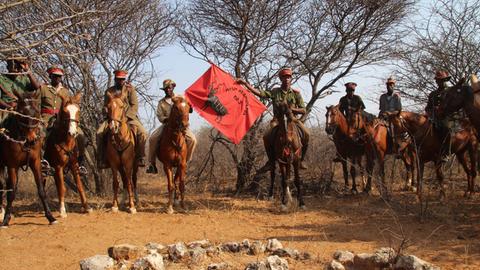 Menschen auf Pferden mit Flaggen: Nachkommen der Herero gedenken der Opfer des Völkermordes durch die Deutschen.