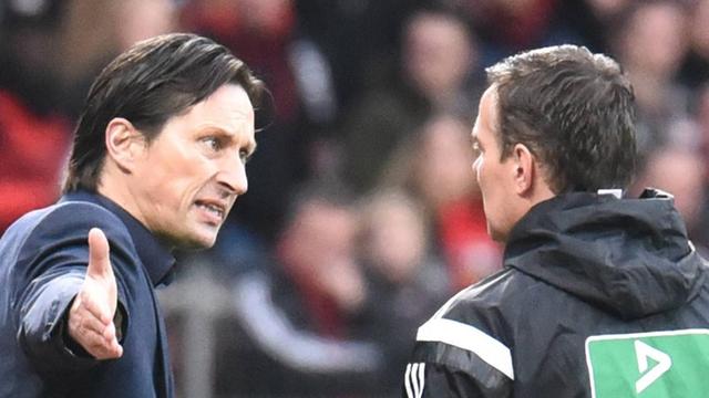 Leverkusens Trainer Roger Schmidt (l.) redet auf den Vierten Offiziellen Christoph Bornhorst ein.