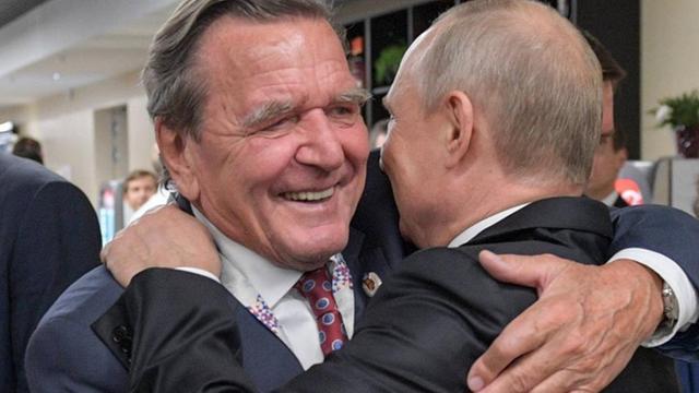 Russlands Präsident Wladimir Putin und Altkanzler Gerhard Schröder umarmen sich bei der Eröffnung der Fußballweltmeisterschaft 2018
