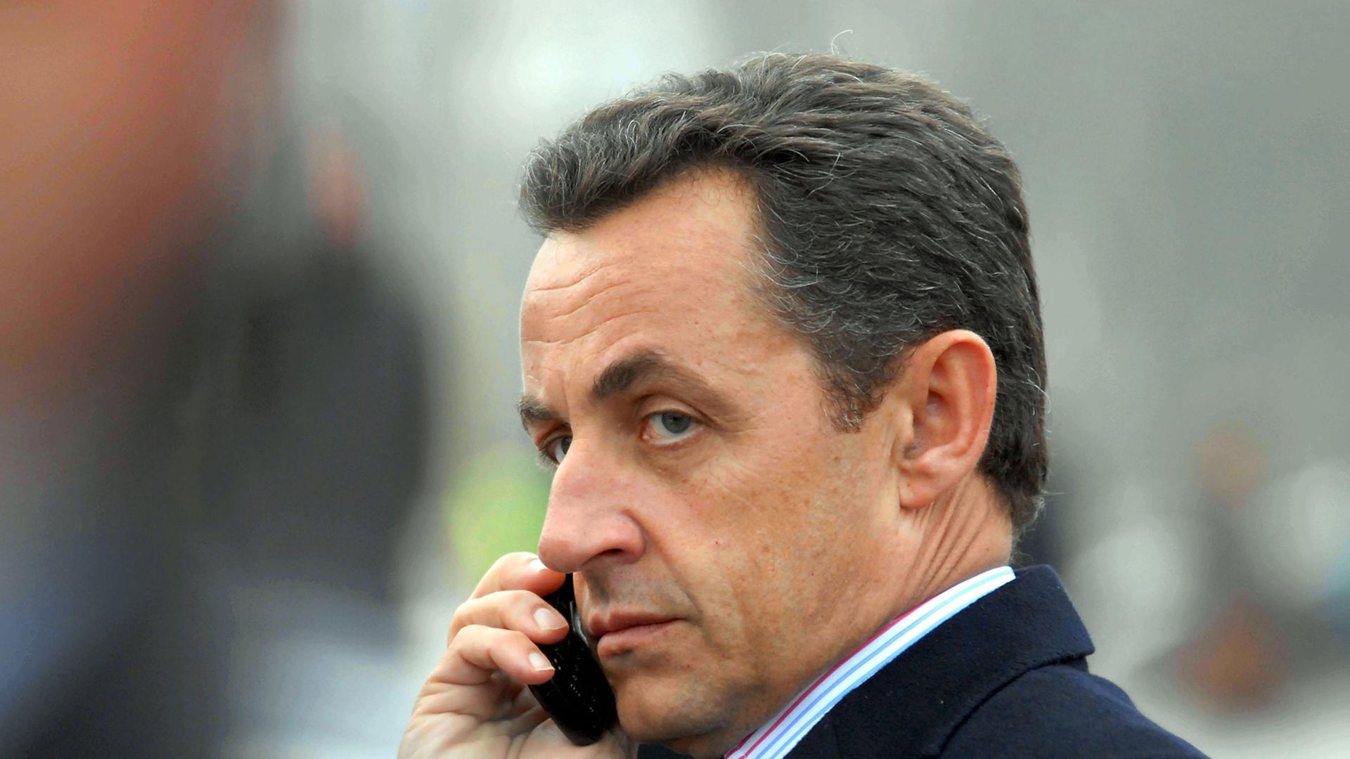 Nicolas Sarkozy telefoniert mit einem Handy. Nicolas Sarkozy telefoniert mit einem Handy.