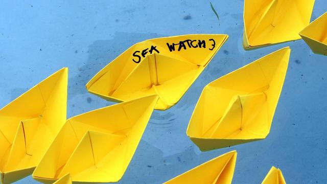 Gelbe Papierschiffchen, die Flüchtlingsboote auf dem Mittelmeer darstellen sollen, wurden von Demonstranten in das Wasser des Brunnens am Schlossplatz gesetzt. Ein Schiffchen trägt die Aufschrift Sea Watch 3.