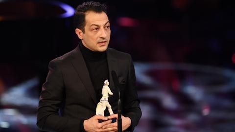 Der Komponist Arash Safaian erhält bei der Verleihung des Bayerischen Filmpreises im Prinzregententheater seine Auszeichnung in Form des "Pierrot".