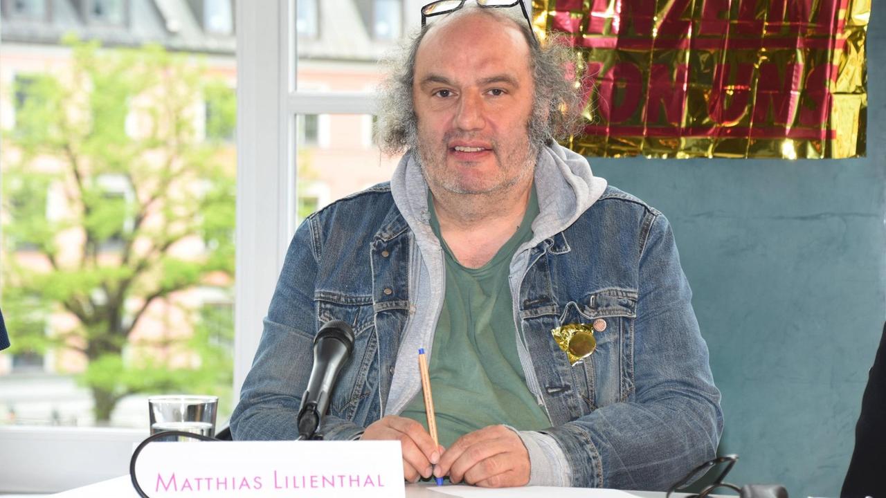 Regisseur Matthias Lilienthal sitzt hinter einem Schild, auf dem sein Name steht.