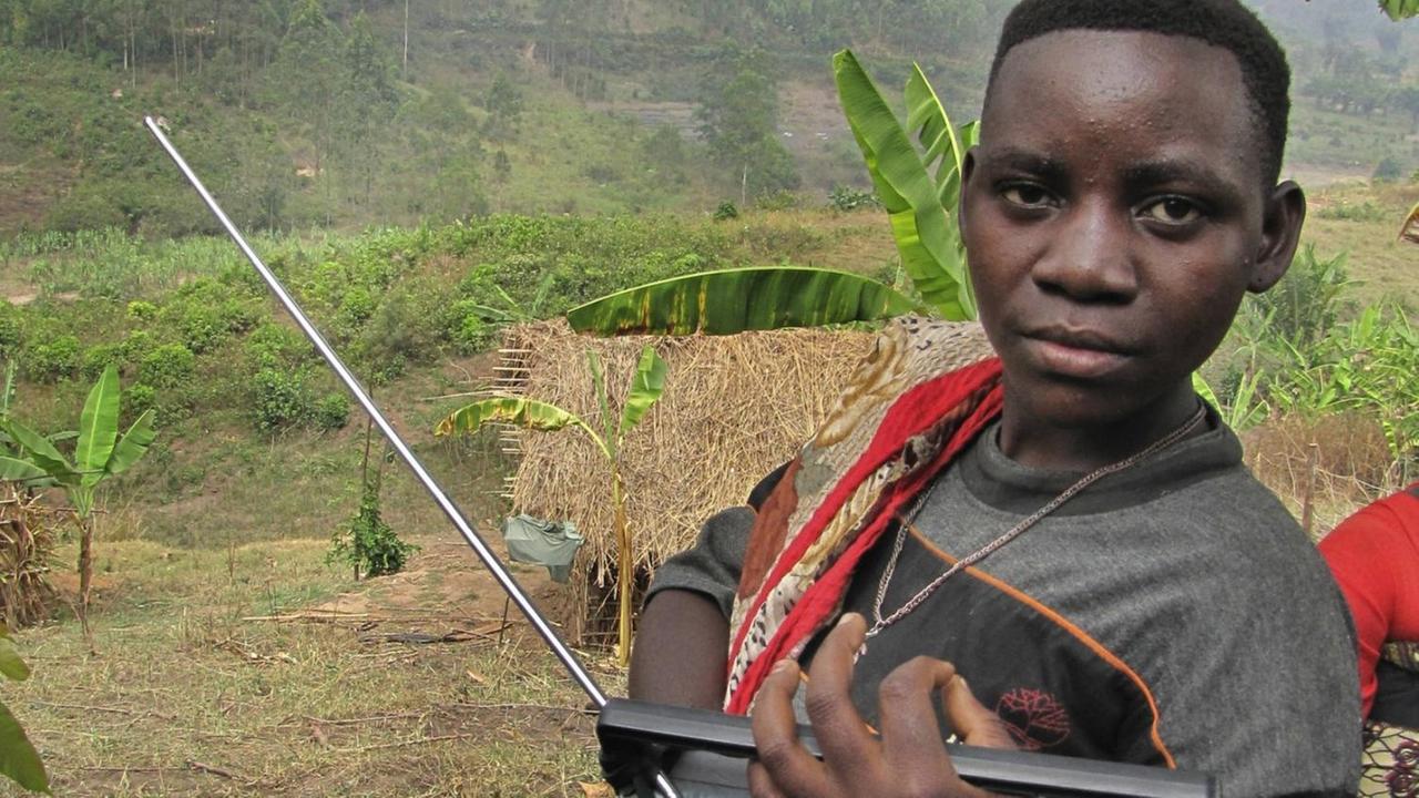 Eine junge Frau - sie ist Angehörige der Minorität der Batwa in Ruanda - hört Radio Eine junge Frau - sie ist Angehörige der Minorität der Batwa in Ruanda - hört Radio