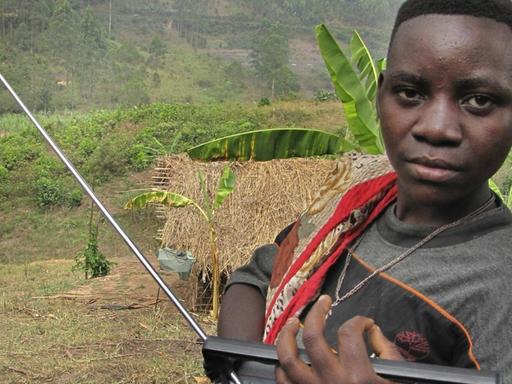 Eine junge Frau - sie ist Angehörige der Minorität der Batwa in Ruanda - hört Radio