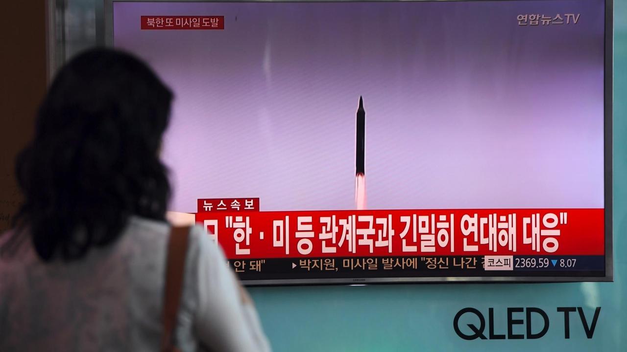 Eine Frau betrachtet in einem Bahnhof in Seoul einen Fernsehbildschirm mit Aufnahmen eines nordkoreanischen Raketentests. Eine Frau betrachtet in einem Bahnhof in Seoul einen Fernsehbildschirm mit Aufnahmen eines nordkoreanischen Raketentests.