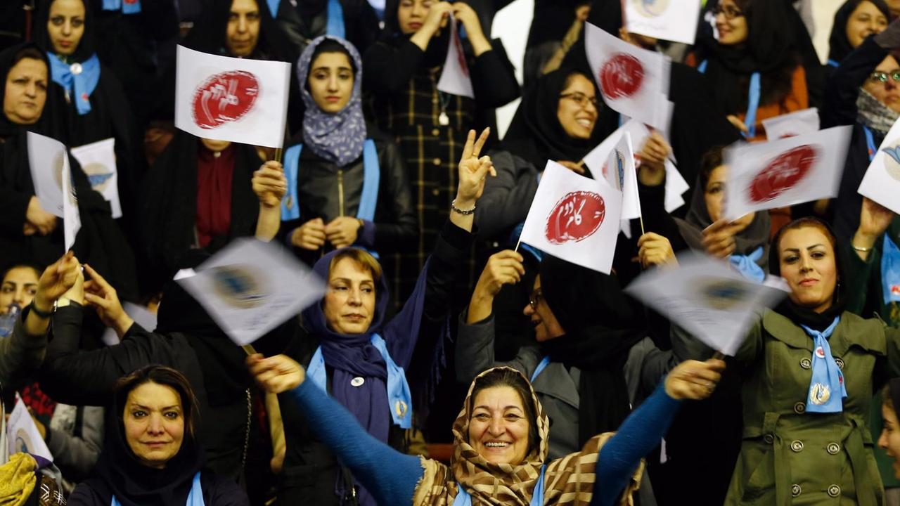 Man sieht eine Gruppe von Frauen mit blauen Schals und Schildern. Man sieht eine Gruppe von Frauen mit blauen Schals und Schildern.