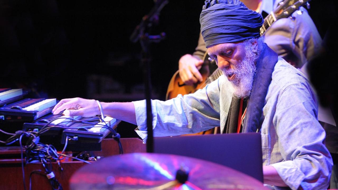 Lonnie Smith mit weißem Bart an der Orgel. Neben ihm steht ein Laptop. Lonnie Smith mit weißem Bart an der Orgel. Neben ihm steht ein Laptop.