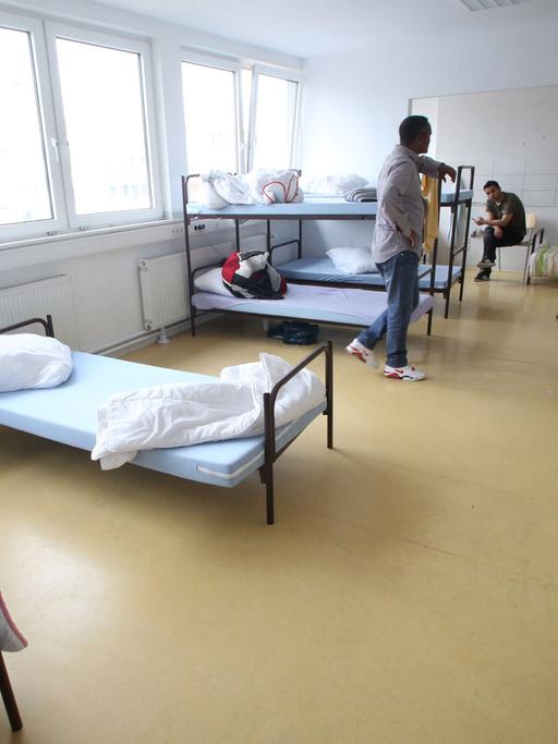 Flüchtlinge halten sich in der Flüchtlingsunterkunft in Essen in ihrem Vielbettzimmer auf.