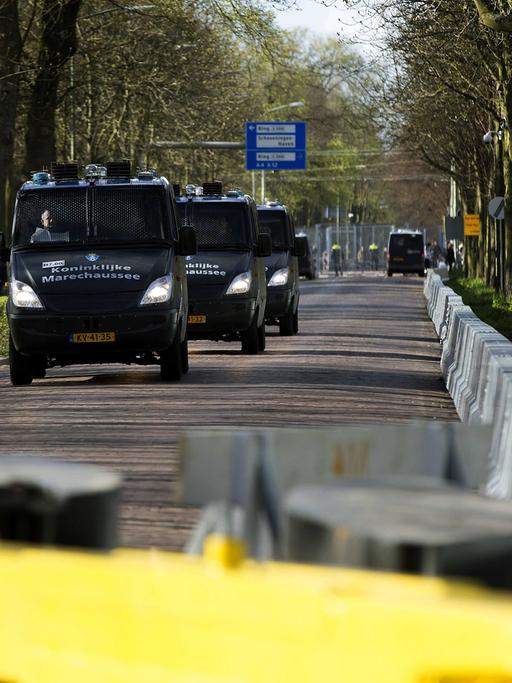 Fahrzeuge der royalen Militärpolizei fahren im Konvoi auf einer gesperrten Straße in Den Haag, Niederlanden.