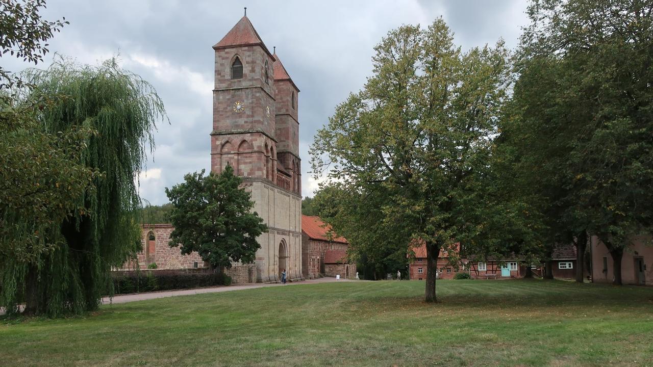 Ansicht der Klosterruine von Veßra inmitten grüner Wiesen und Bäume.