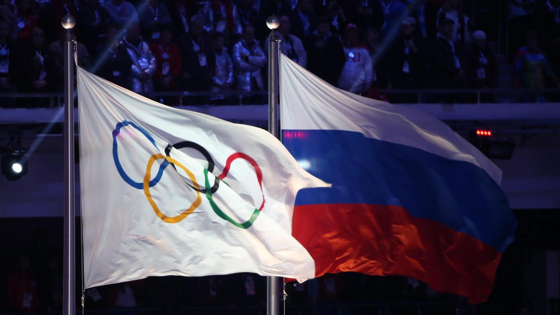 Die russische und die olympische Flagge während der Schlussfeier der olympischen Spiele in Sotschi /Russland