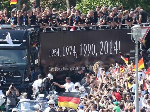 Die deutsche Nationalmannschaft wird am 15.07.2014 in Berlin auf ihrer Fahrt zur Fanmeile am Brandenburger Tor von den Fans empfangen.