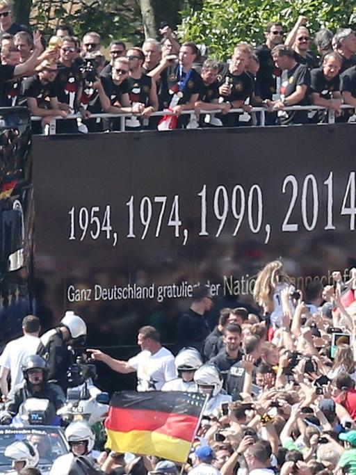 Die deutsche Nationalmannschaft wird am 15.07.2014 in Berlin auf ihrer Fahrt zur Fanmeile am Brandenburger Tor von den Fans empfangen.