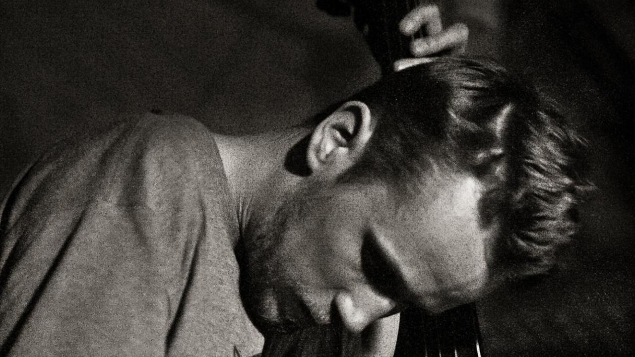 Der Bassist ist auf einem s/w Bild vertieft in sein Spiel zu sehen Der Bassist ist auf einem s/w Bild vertieft in sein Spiel zu sehen