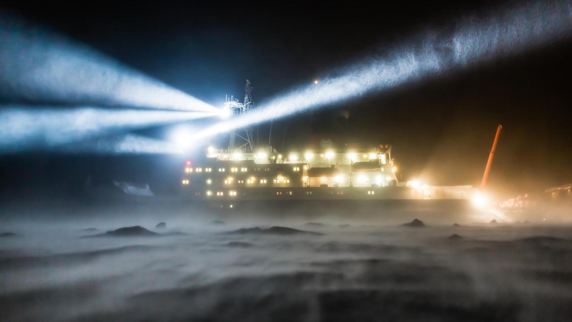 Das Forschungsschiff Polarstern während einer Eisstation mit starken Winden und einer starken Schneedrift.
