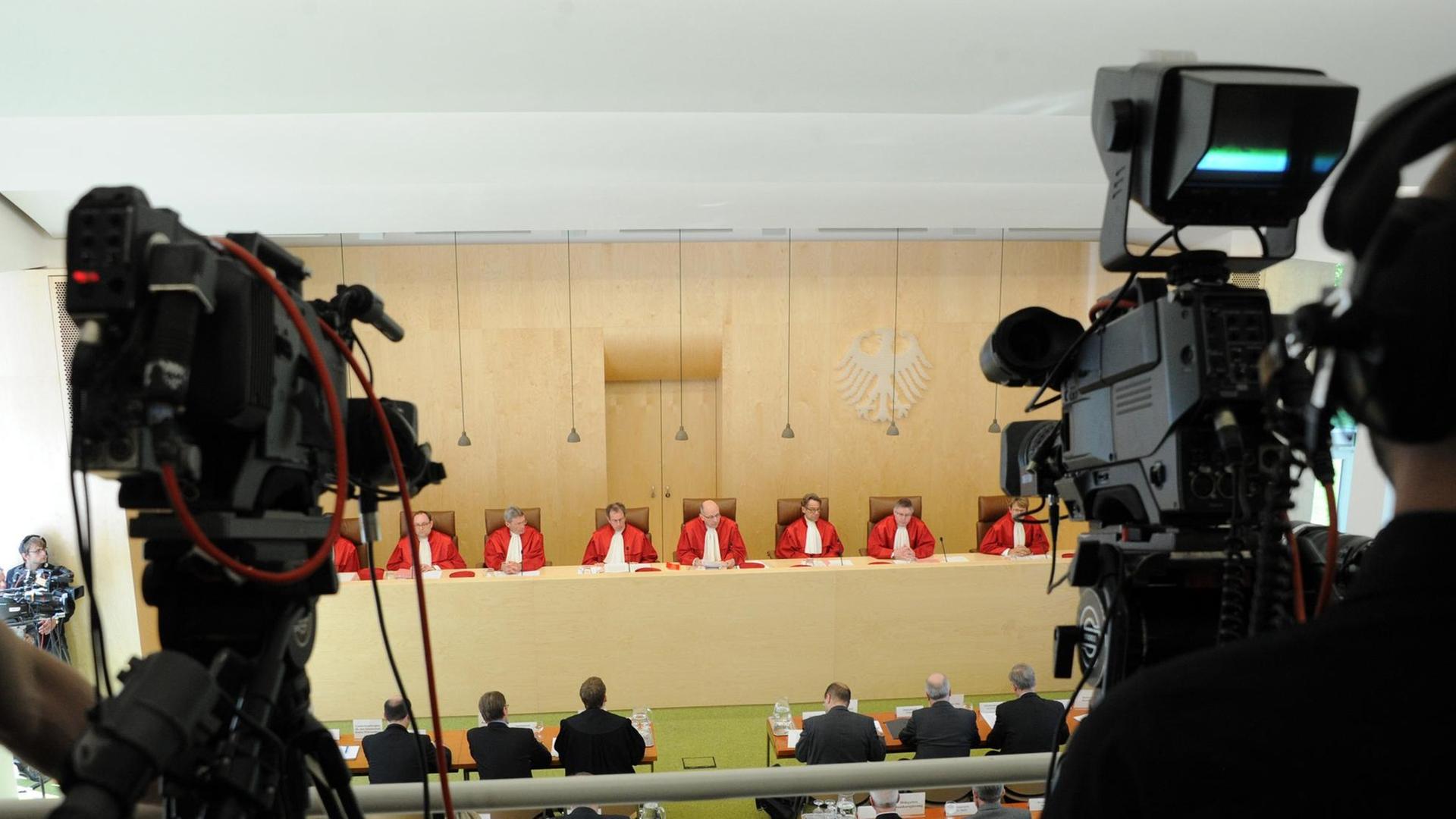 Der Erste Senat beim Bundesverfassungsgericht in Karlsruhe: Gabriele Britz (l-r), Andreas Paulus, Michael Eichberger, Johannes Masing , Ferdinand Kirchhof (Vorsitz), Reinhard Gaier, Wilhelm Schluckebier und Susanne Baer, verkündet am 24.04.2013 in Karlsruhe sein Urteil zur Antiterrordatei. Eine Kamera filmt die Verkündung. Der Erste Senat beim Bundesverfassungsgericht in Karlsruhe: Gabriele Britz (l-r), Andreas Paulus, Michael Eichberger, Johannes Masing , Ferdinand Kirchhof (Vorsitz), Reinhard Gaier, Wilhelm Schluckebier und Susanne Baer, verkündet am 24.04.2013 in Karlsruhe sein Urteil zur Antiterrordatei. Eine Kamera filmt die Verkündung.