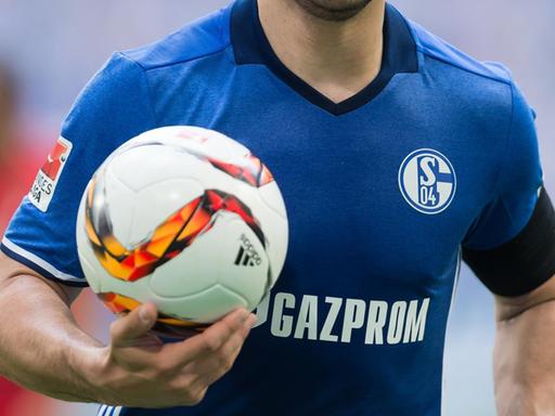 Ein Schalker Spieler mit dem neuen Trikot der Saison 2016/2017 hält einen Ball in der Hand.