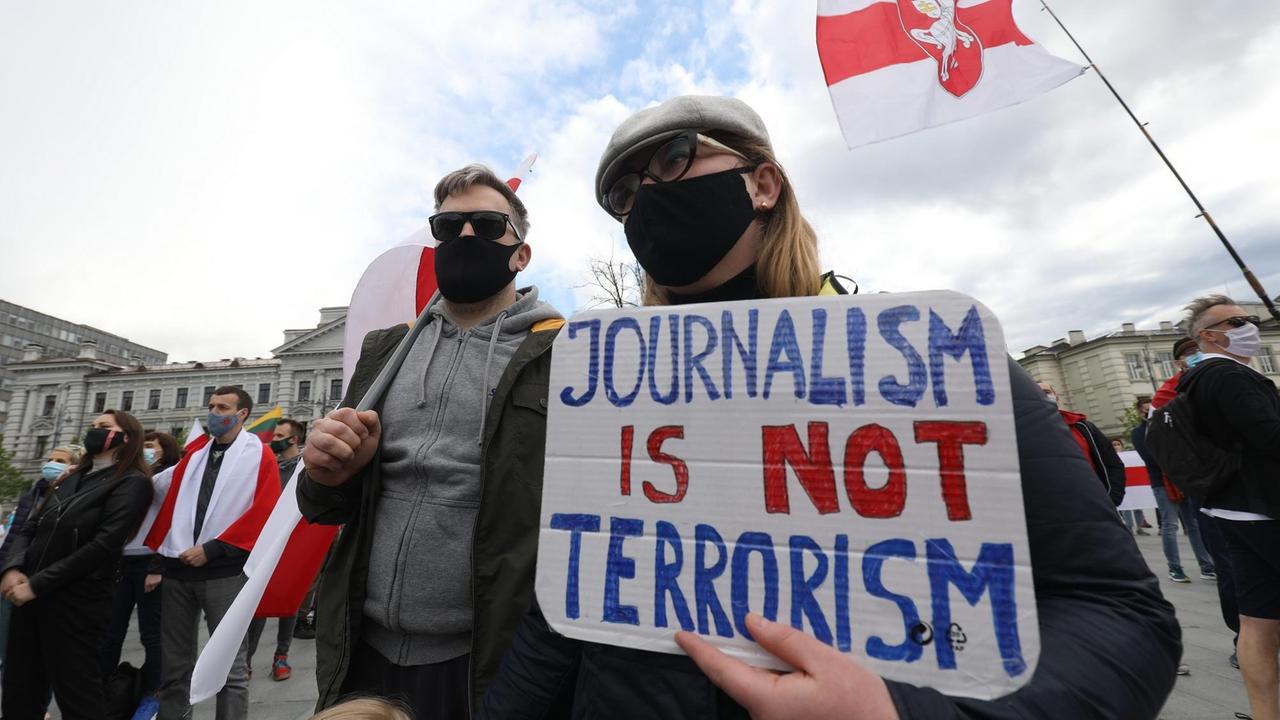 Protestierende halten ein Schild mit der Aufschrift: "Journalism ist not Terrorism / Journalismus ist kein Terrorismus". Protestierende halten ein Schild mit der Aufschrift: "Journalism ist not Terrorism / Journalismus ist kein Terrorismus".