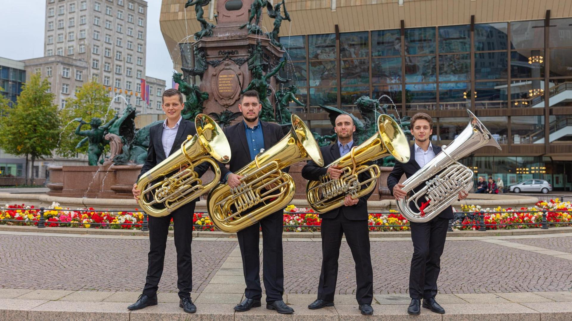 Vier Musiker stehen mit ihren Instrumenten vor dem Gewandhaus Leipzig Vier Musiker stehen mit ihren Instrumenten vor dem Gewandhaus Leipzig