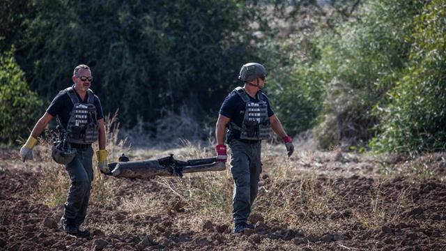 Israelische Soldaten tragen einen Teil einer Rakete die vom Gazastreifen auf Israel geschossen wurde.