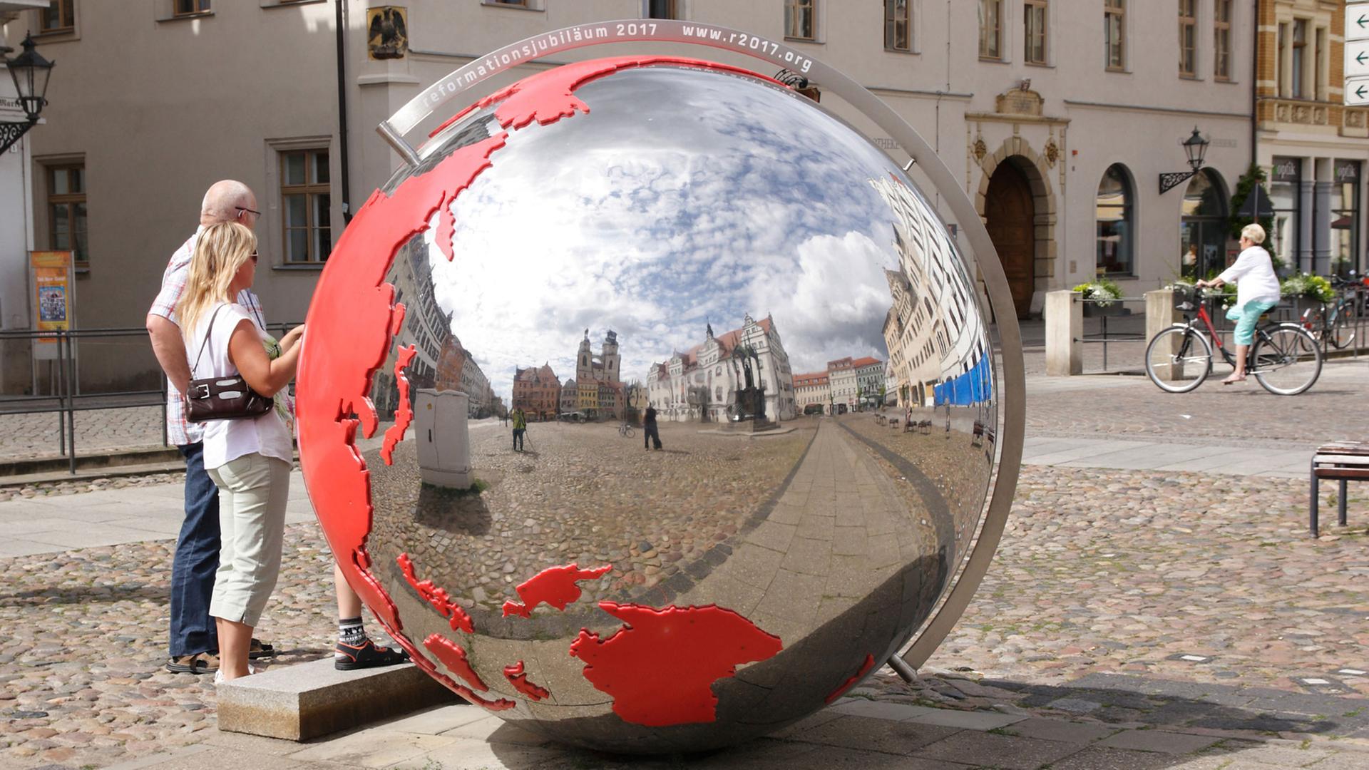 In der großen Erdkugel auf dem Marktplatz der Lutherstadt Wittenberg spiegeln sich: Rathaus, Melanchthon- und Luther-Denkmal und die Stadtkirche St. Marien. In der großen Erdkugel auf dem Marktplatz der Lutherstadt Wittenberg spiegeln sich: Rathaus, Melanchthon- und Luther-Denkmal und die Stadtkirche St. Marien.