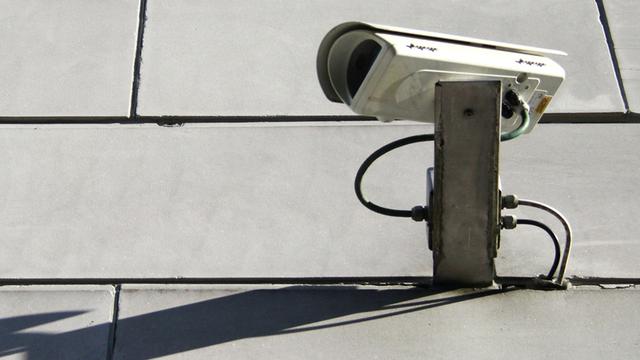Eine Überwachungskamera hängt an der Fassade der Bayerischen Staatskanzlei in München.