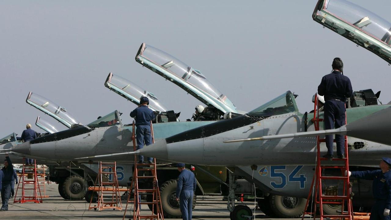 Die Kampfjets werden von Technikern gewartet, die auf roten Leitern an den Cockpits stehen. Darin sitzen Piloten mit Helmen. Die Glasklappen der Cockpits sind geöffnet. Die Kampfjets werden von Technikern gewartet, die auf roten Leitern an den Cockpits stehen. Darin sitzen Piloten mit Helmen. Die Glasklappen der Cockpits sind geöffnet.