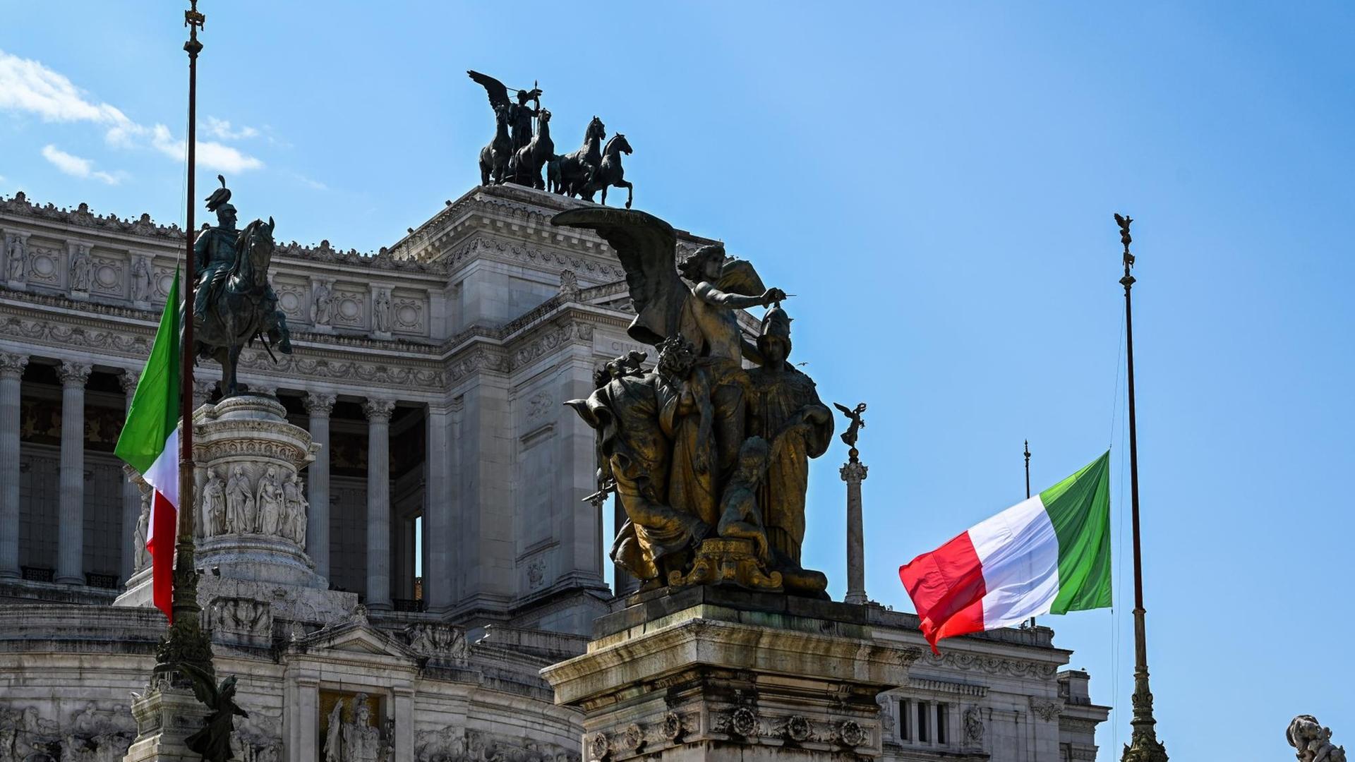 In Italien wehen die Flaggen aus Trauer um die Corona-Toten auf Halbmast - wie hier am "Altare della Patria - Vittorio Emanuele II" in Rom. In Italien wehen die Flaggen aus Trauer um die Corona-Toten auf Halbmast - wie hier am "Altare della Patria - Vittorio Emanuele II" in Rom.