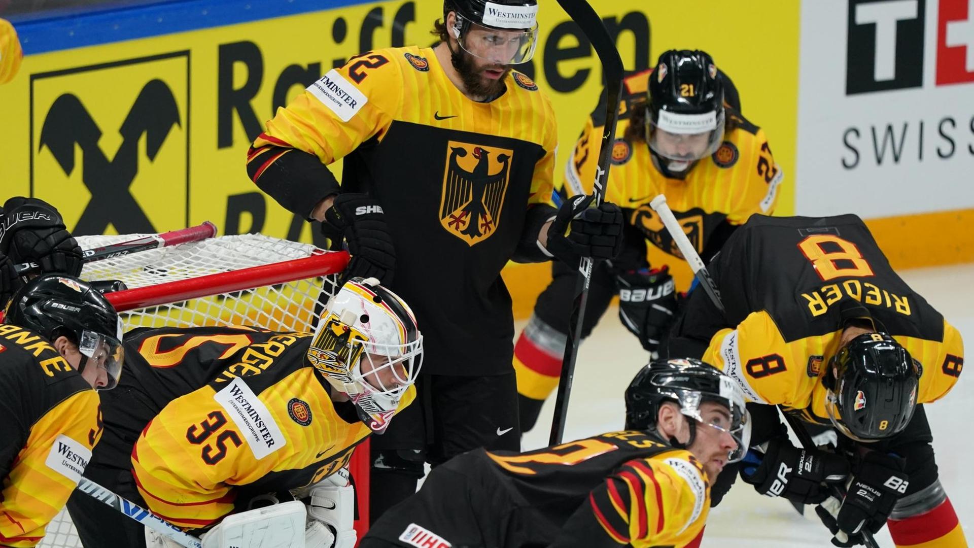 Im Spiel gegen Kanada unterstützen mehrere deutsche Eishockey-Spieler ihren Torwart.