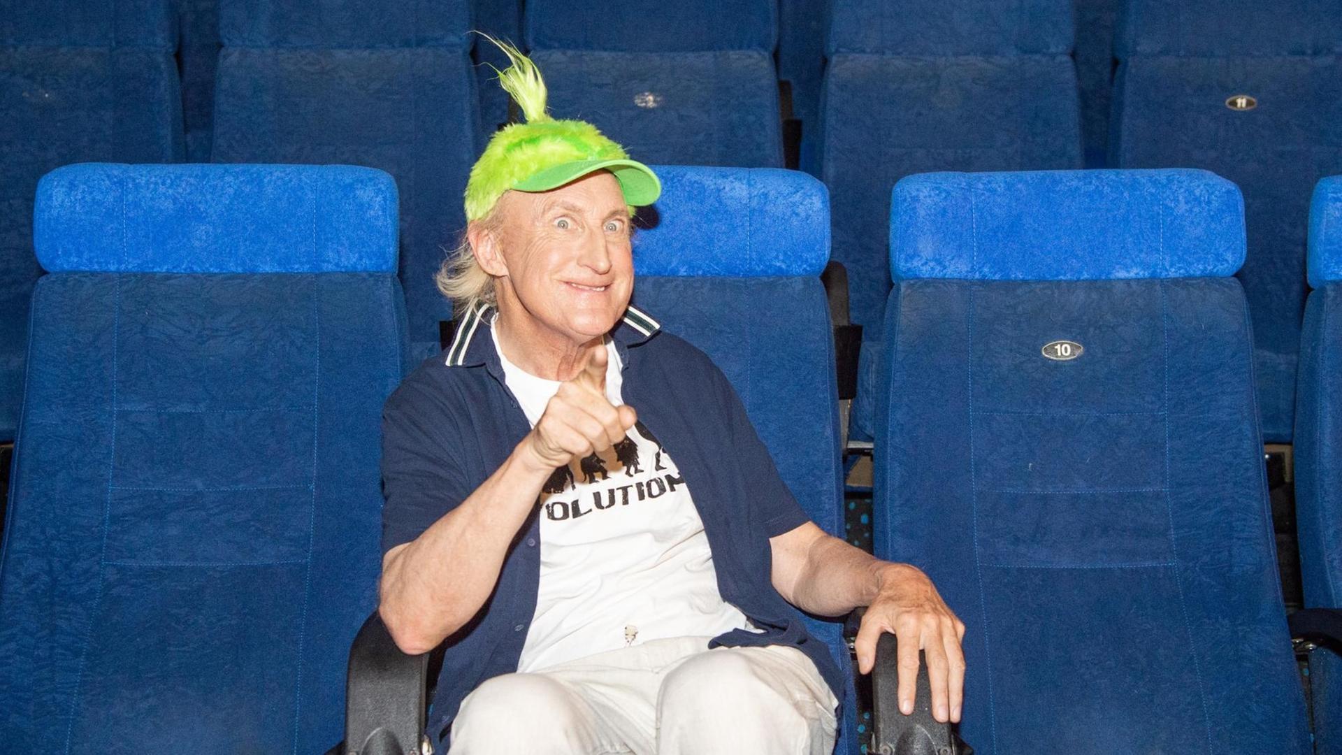 ACHTUNG: SPERRFRIST 7. AUGUST 18:45 UHR. - 07.08.2018, Nordrhein-Westfalen, Düsseldorf: Der Komiker Otto Waalkes sitzt mit einer grünen Püschmütze in einem Kino. Der 70-Jährige leihe für den Animationsfilm «Der Grinch» in der deutschen Synchronisation dem grünen Griesgram seine Stimme, teilte Universal Pictures International Germany am 07.08.2018 anlässlich der Filmmesse in Düsseldorf mit. (zu dpa "Otto Waalkes spricht den «Grinch» - Komiker wird zum Griesgram" vom 07.08.2018) Foto: Christophe Gateau/dpa | Verwendung weltweit ACHTUNG: SPERRFRIST 7. AUGUST 18:45 UHR. - 07.08.2018, Nordrhein-Westfalen, Düsseldorf: Der Komiker Otto Waalkes sitzt mit einer grünen Püschmütze in einem Kino. Der 70-Jährige leihe für den Animationsfilm «Der Grinch» in der deutschen Synchronisation dem grünen Griesgram seine Stimme, teilte Universal Pictures International Germany am 07.08.2018 anlässlich der Filmmesse in Düsseldorf mit. (zu dpa "Otto Waalkes spricht den «Grinch» - Komiker wird zum Griesgram" vom 07.08.2018) Foto: Christophe Gateau/dpa | Verwendung weltweit