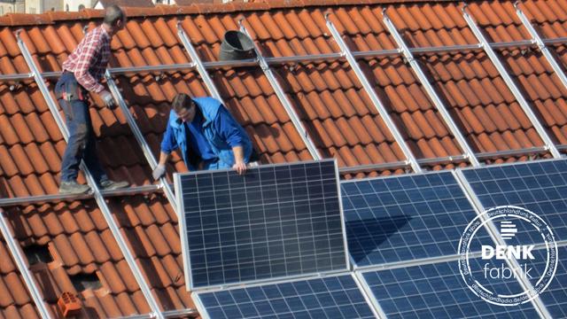 Arbeiter installieren Solarzellen auf einem Dach, aufgenommen am 06.03.2012 in Igersheim.