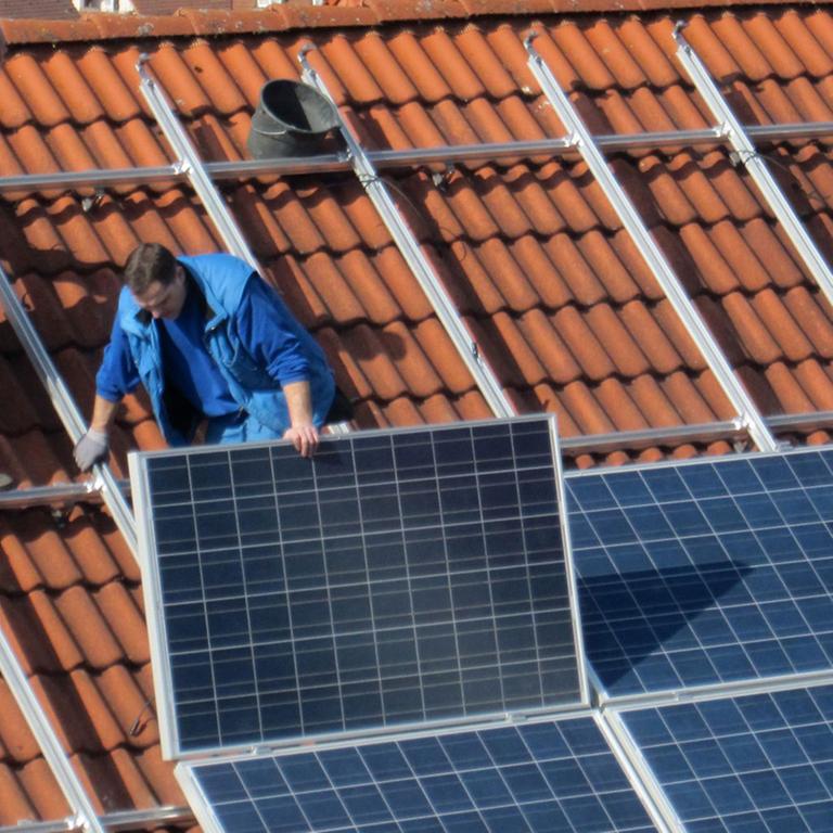 Arbeiter installieren Solarzellen auf einem Dach, aufgenommen am 06.03.2012 in Igersheim. Arbeiter installieren Solarzellen auf einem Dach, aufgenommen am 06.03.2012 in Igersheim.