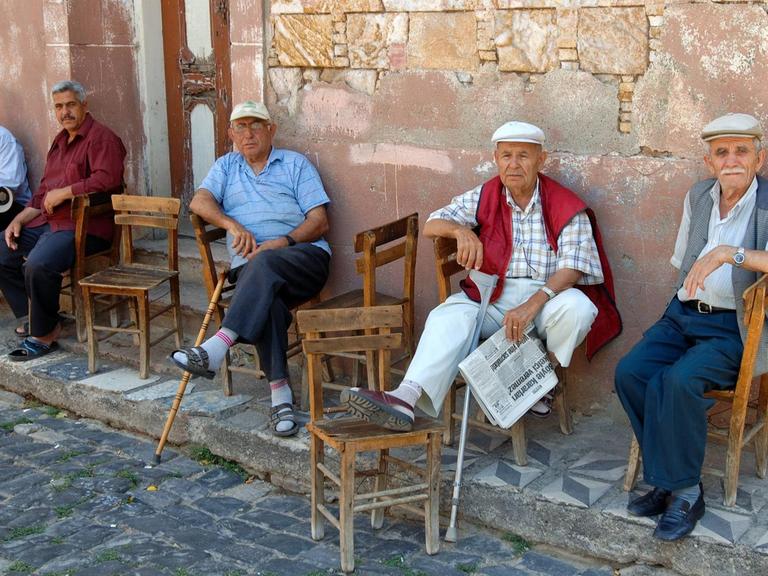 Türkische Rentner sitzen vor einem Haus in Ayvalik.